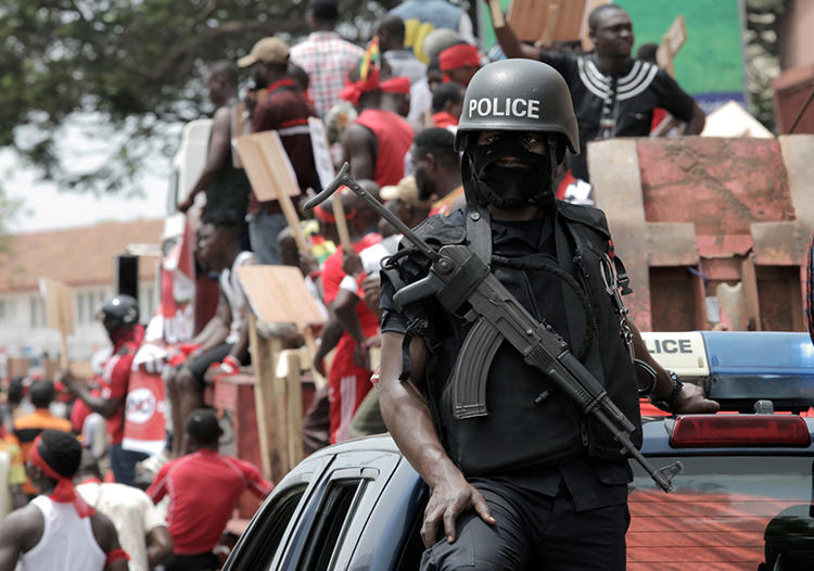 A police officer stands guard as demonstrators take part during a protest against the expansion of its defence cooperation with the United States, in Accra