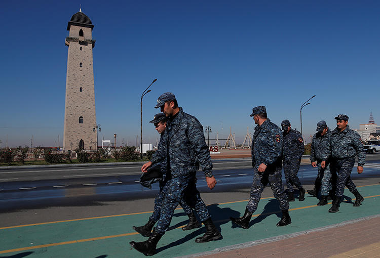 Police officers walk during a protest against the new land swap deal, agreed by the heads of the Russian regions of Ingushetia and Chechnya, in Ingushetia's capital Magas